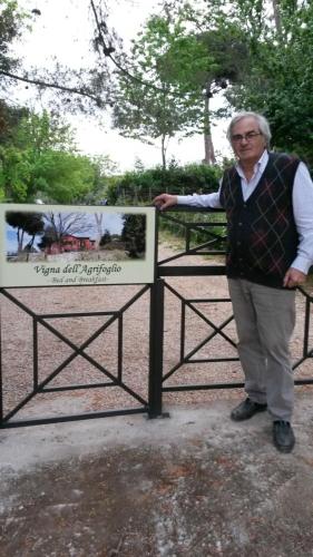 a man standing next to a sign in a park at Vigna dell'Agrifoglio - Bed and Breakfast in Velletri