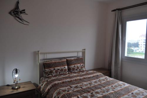a bedroom with a large bed with a window at Alp Apartment in Mağusa
