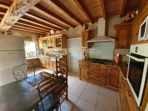 a kitchen with wooden cabinets and a table and chairs at Halte Mobilité Professionnelle au Mois in Agen