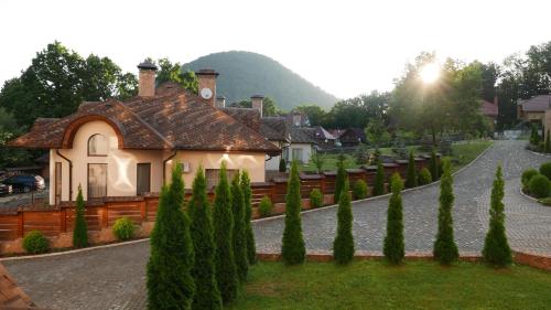 a house in a garden with cypress trees at LETIZIA country club in Shaian