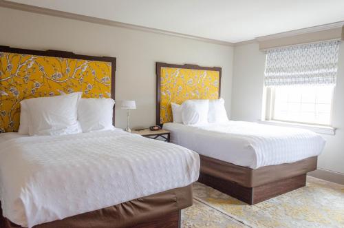a bedroom with two beds and a window at The Bolling Wilson Hotel in Wytheville