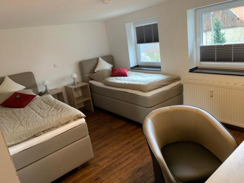 ein Zimmer mit 2 Betten und einem Stuhl darin in der Unterkunft Hotel Stegmann's Hof in Sehnde