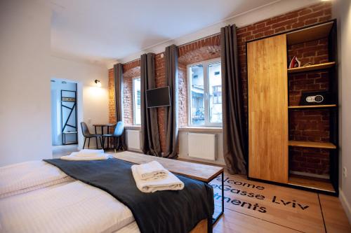 a bedroom with a bed and a brick wall at Neue Gasse Lviv apartments in Lviv