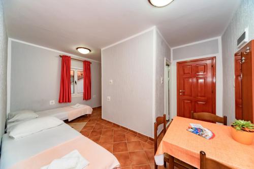 a room with two beds and a table and a window at Villa Glavanovic in Bar
