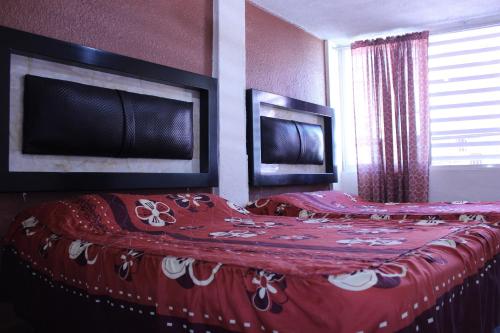 a bedroom with a bed with a red blanket at Hotel Plaza Aleman in León