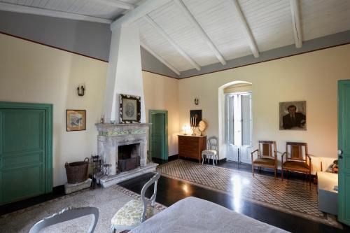 a living room with a fireplace and green doors at Villa Cammarana in Ragusa