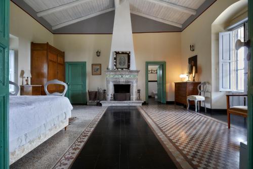 a bedroom with a bed and a fireplace at Villa Cammarana in Ragusa