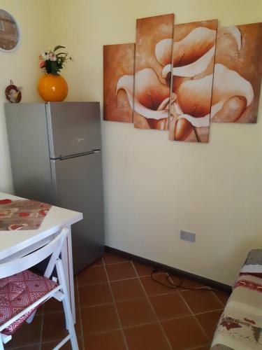 a kitchen with four paintings on the wall at Casa Vacanze Paola 2 in Santa Luria