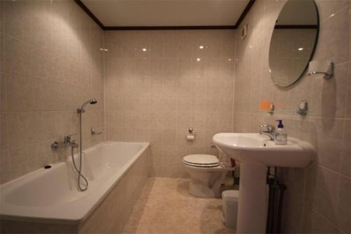 une salle de bain avec un lavabo, une baignoire et des toilettes dans l'établissement Domaine de vacances à 600m de la plage villa 4 chambres 9 couchages WIFI terrasse parking animations et piscines en supplément LRPDSH4, à Portiragnes