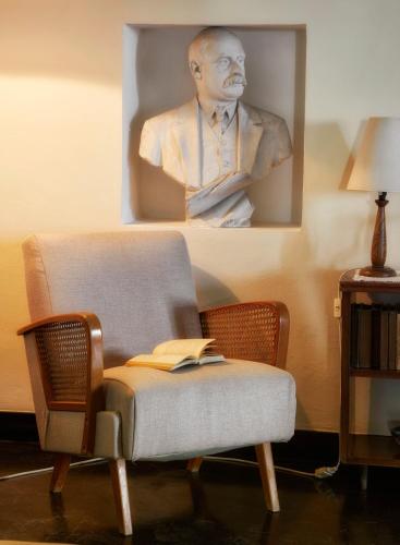 a picture of a man with a book on a chair at Villa Cammarana in Ragusa