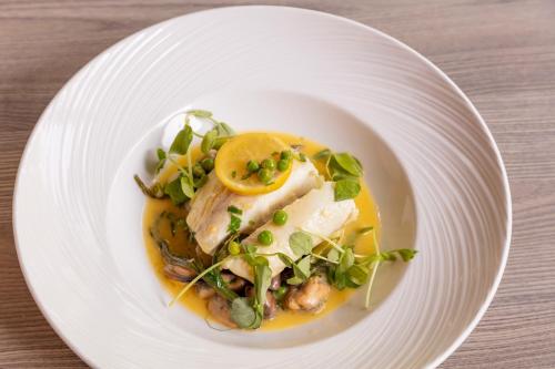 a white plate with a dish of food on a table at Novotel Newcastle Airport in Newcastle upon Tyne