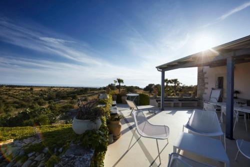 a patio with chairs and a view of the desert at Villa Cammarana in Ragusa