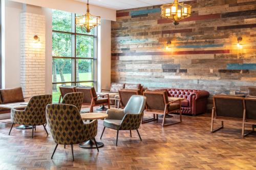 a restaurant with chairs and a brick wall at Novotel Newcastle Airport in Newcastle upon Tyne