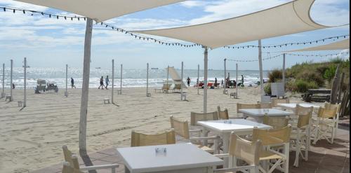 a restaurant on the beach with tables and chairs at Bilocale Marina Romea in Marina Romea