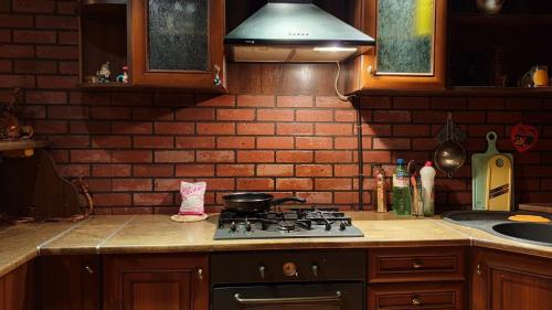 a kitchen with a stove and a brick wall at Viktoria in Uzhhorod