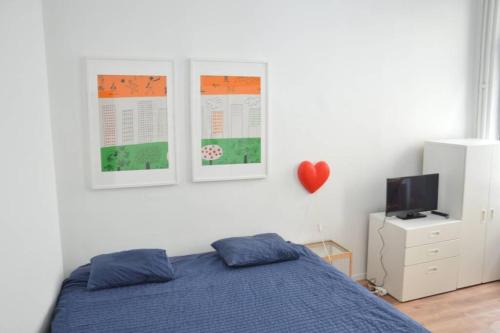 a bedroom with a blue bed and a tv at Awesome Studio in Marolles in Brussels