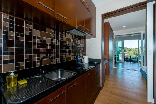 a kitchen with a sink and a counter top at Sea and Sky by Phuket Rent Angel in Karon Beach
