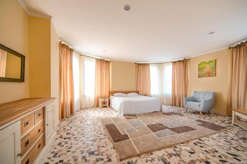 a bedroom with a bed and a chair at LETIZIA country club in Shaian