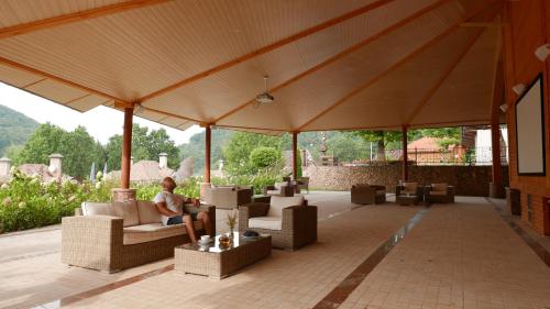 a man sitting on a chair under a pavilion at LETIZIA country club in Shaian