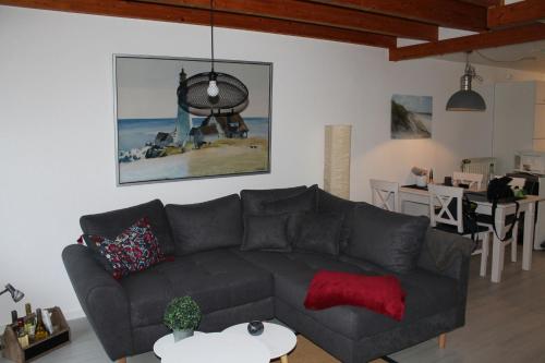 a living room with a black couch and a table at Ferienwohnung Yachthof Scheid in Scheid