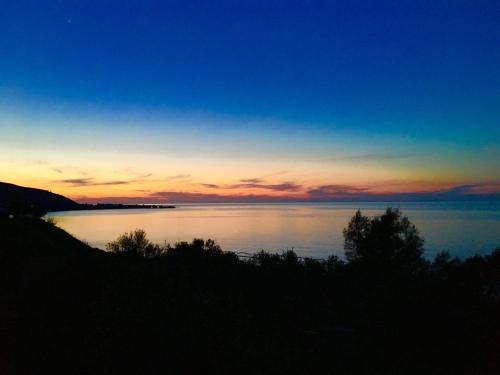 a sunset over a large body of water at A.A Michael Apartments in Pachyammos