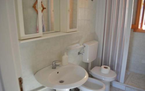 ein weißes Badezimmer mit Waschbecken und Toilette in der Unterkunft Casa a Torre dell Orso Pt55 in Torre dell'Orso