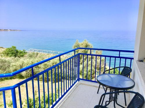 a balcony with a table and chairs and the ocean at A.A Michael Apartments in Pachyammos