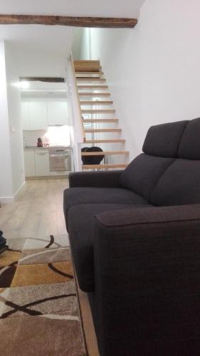 a living room with a couch and a staircase at Apartamentos Turísticos Los Picos in Liérganes