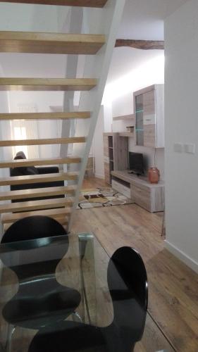 a living room with a glass table and a staircase at Apartamentos Turísticos Los Picos in Liérganes