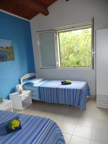 a bedroom with two beds and a window at La Perla di Sicilia in Marina di Modica