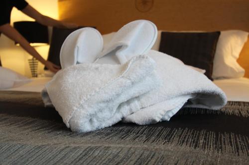 a towel animal on a bed in a hotel room at Belgrave Sands Hotel & Spa in Torquay
