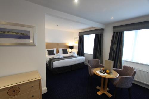 Habitación de hotel con cama y escritorio con ordenador portátil en Belgrave Sands Hotel & Spa, en Torquay