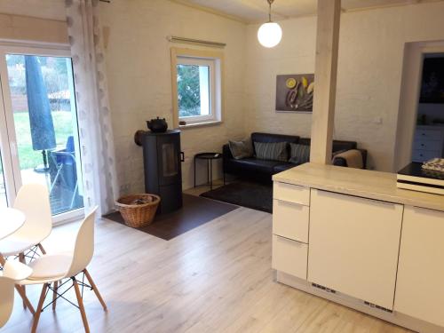 eine Küche und ein Wohnzimmer mit einem Sofa und einem Tisch in der Unterkunft Cottage am Wald bei Berlin in Falkensee
