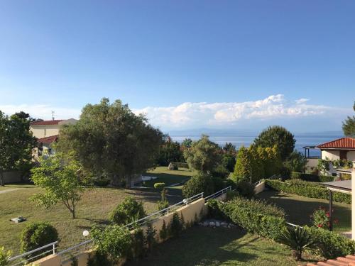 a view of a garden with the ocean in the background at Villa Dimitrios in Kriopigi