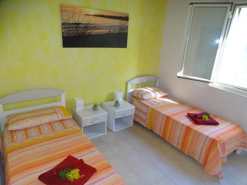 a bedroom with two beds and a window at La Perla di Sicilia in Marina di Modica