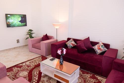 a living room with a purple couch and a table at Swiss Royal DAHAB in Dahab