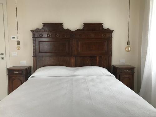 a bed with a wooden headboard and two night stands at Corte Viviani in Brescia