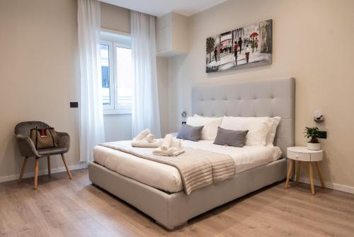 1 dormitorio con 1 cama blanca grande y 1 silla en XXIV Domus Luxury Suites, en Roma