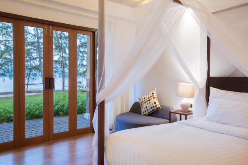 a bedroom with a bed and a window at Mira Montra Resort Koh Mak - SHA Plus in Ko Mak