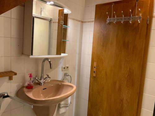 een badkamer met een wastafel en een spiegel bij Ferienwohnung ANHAUS in Koblenz