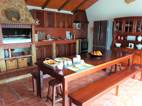a kitchen with wooden cabinets and a wooden table at Casa Branca do Moinho in Salgueiro