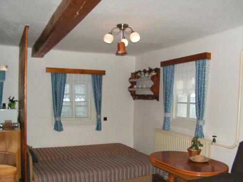 1 dormitorio con 1 cama y 2 ventanas en Krkonosska Chalupa, en Semily