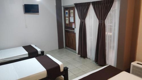 a hotel room with two beds and a window at Hotel Las Colinas in Fortuna