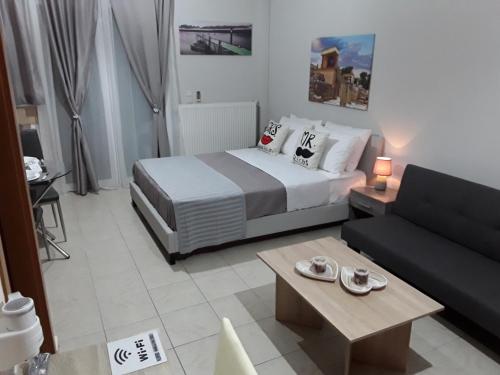 a hotel room with a bed and a couch at Ierapetra Suites & Studios in Ierapetra