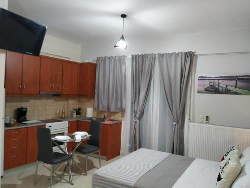 a bedroom with a bed and a small kitchen at Ierapetra Suites & Studios in Ierapetra