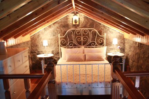 a bedroom with a bed with two lamps on two tables at Moinho da Cascata in Faja Grande