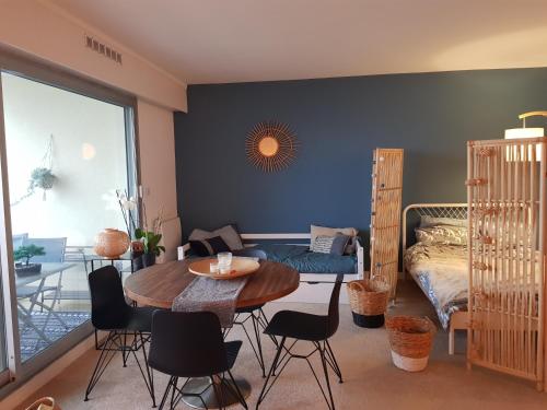 une pièce avec une table, des chaises et un lit dans l'établissement Face mer Tyra, à La Baule