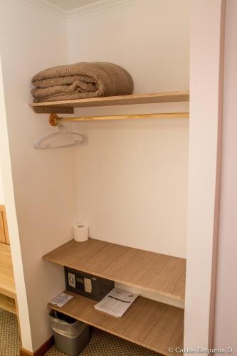 a closet with wooden shelves and a towel at Best Western Patagonia in Puerto Natales