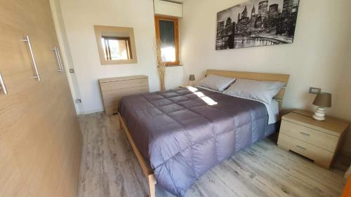 a bedroom with a bed with a purple comforter at APPARTAMENTI TICINO in Sesto Calende