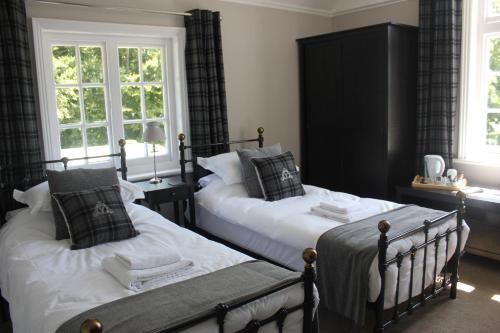 a bedroom with two beds and two windows at Prince of Wales in East Cowes